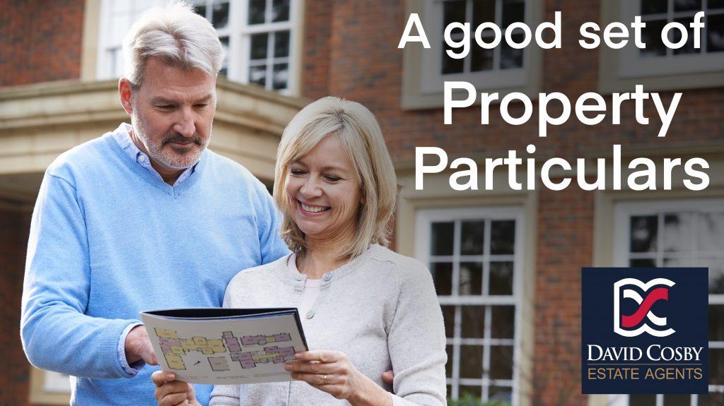 Couple examining a set of property particulars outside a house.