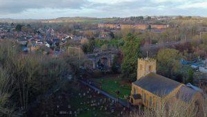 Aerial view of St. Peter and St. Pauls Church, Weedon with railway, village, and Ordnance Depot in background