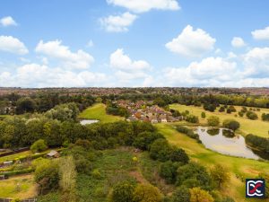 Aerial view of Collingtree Park Golf Course in Northampton, showing fairways, ponds and surrounding countryside with nearby housing.