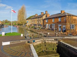 Stoke Bruerne canal lock and historic waterside village scene on the Grand Union Canal in Northamptonshire.